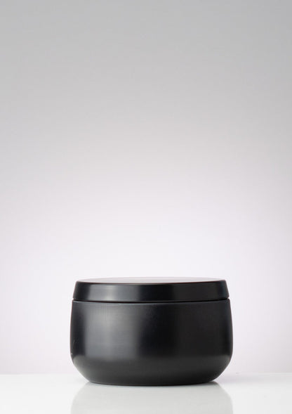 Rounded matte-black candle tin with matching lid