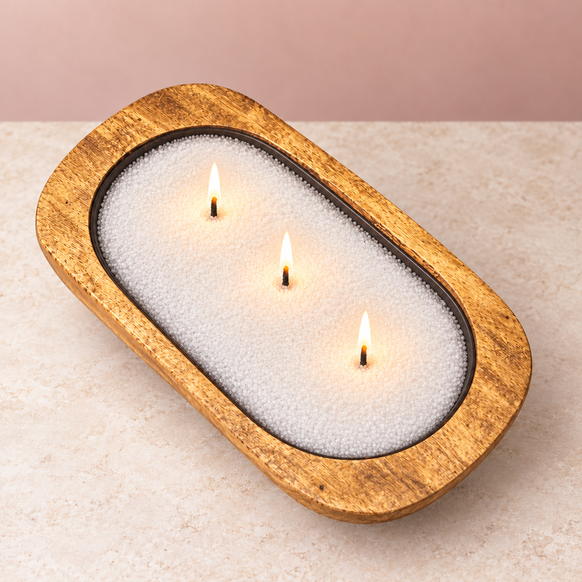 Ready to Glow wooden dough bowl with white candle sand, three lit black wicks, and a dark insert